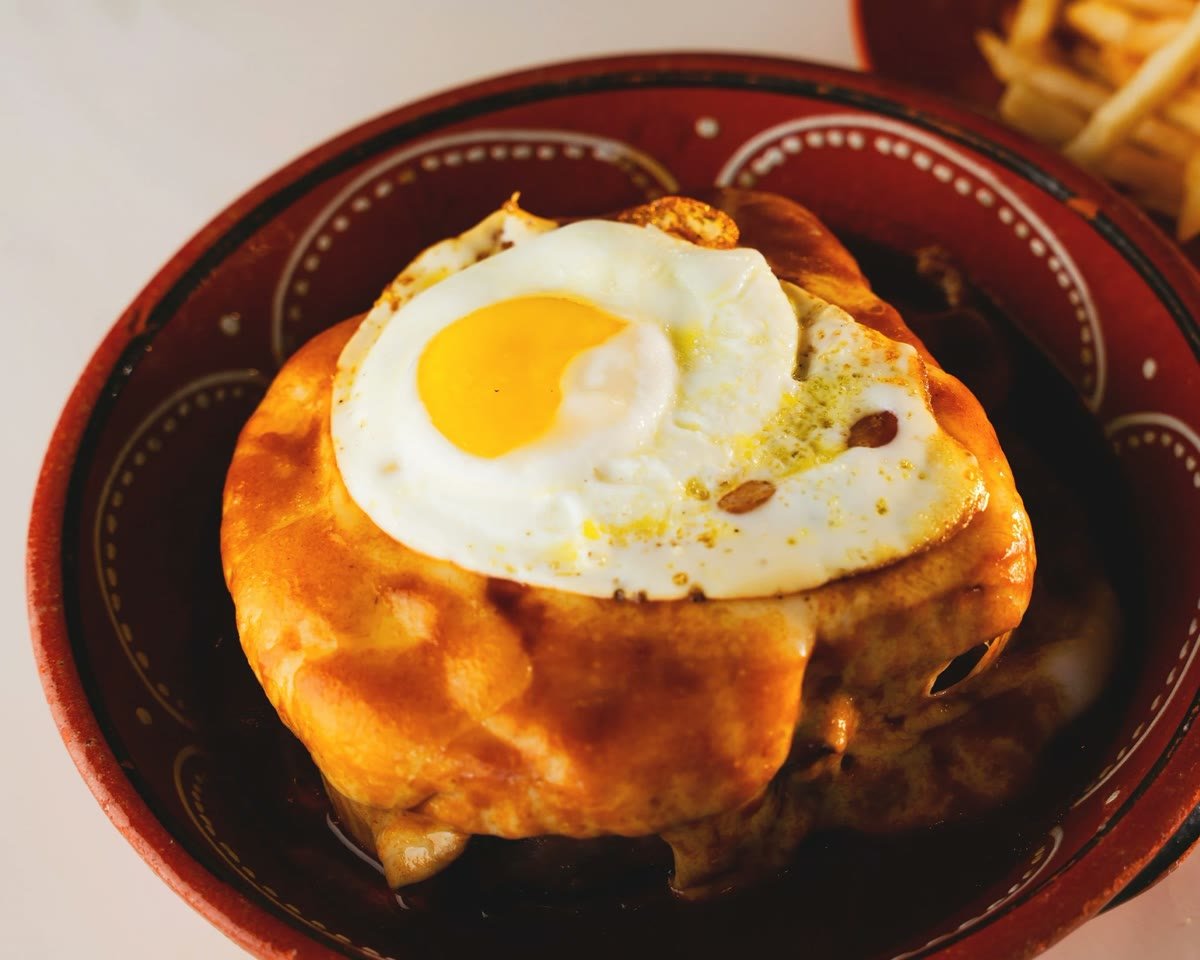 The Francesinha under its beer-based sauce with a fried egg
